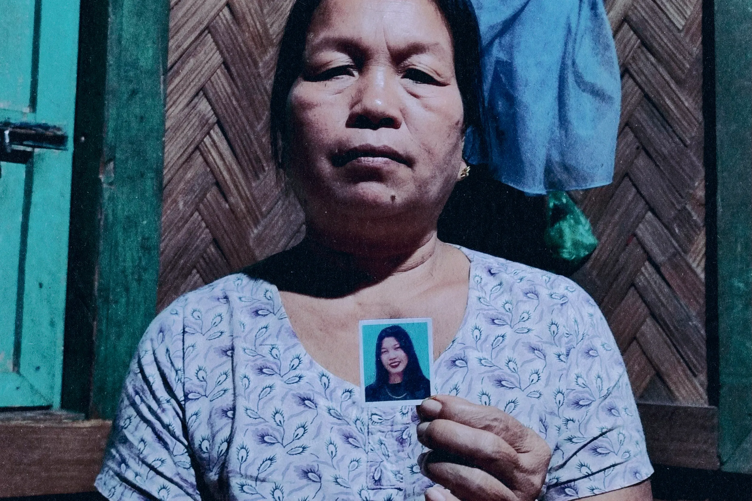 জিং নুন মাওয়ি তার মেয়ে টিনার ছবি হাতে ধরে আছেন